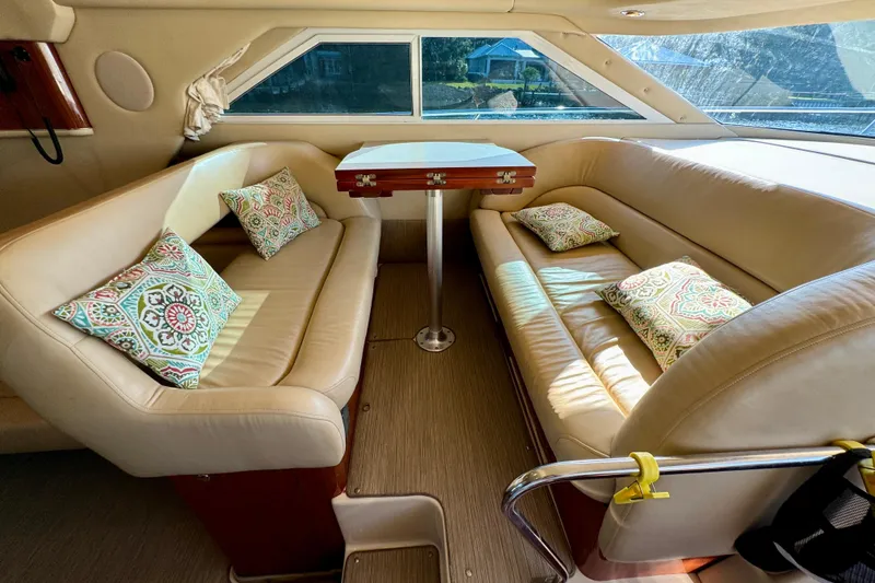 Slide: The Image of Luxurious interior of 2003 Sea Ray 400 Sedan Bridge with beige seating and decorative pillows. - 28