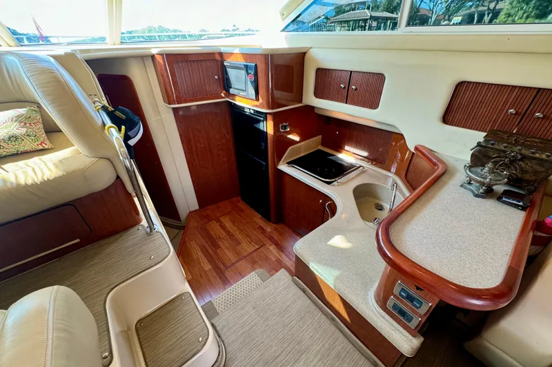 Slide: The Image of Interior of 2003 Sea Ray 400 Sedan Bridge yacht, featuring kitchen and seating area. - 29