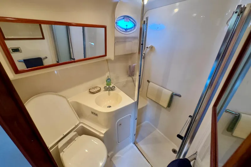 Slide: The Image of 2003 Sea Ray 400 Sedan Bridge bathroom with shower, sink, and toilet. - 34