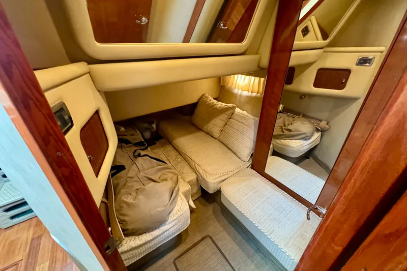 Slide: The Image of 2003 Sea Ray 400 Sedan Bridge cabin interior with cozy seating and wooden accents. - 35