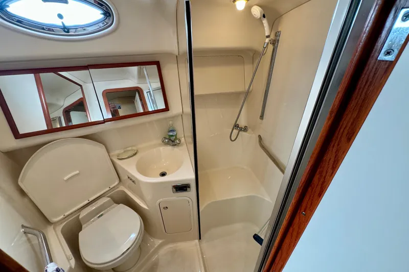 Slide: The Image of Bathroom interior of 2003 Sea Ray 400 Sedan Bridge yacht, featuring shower and toilet. - 38