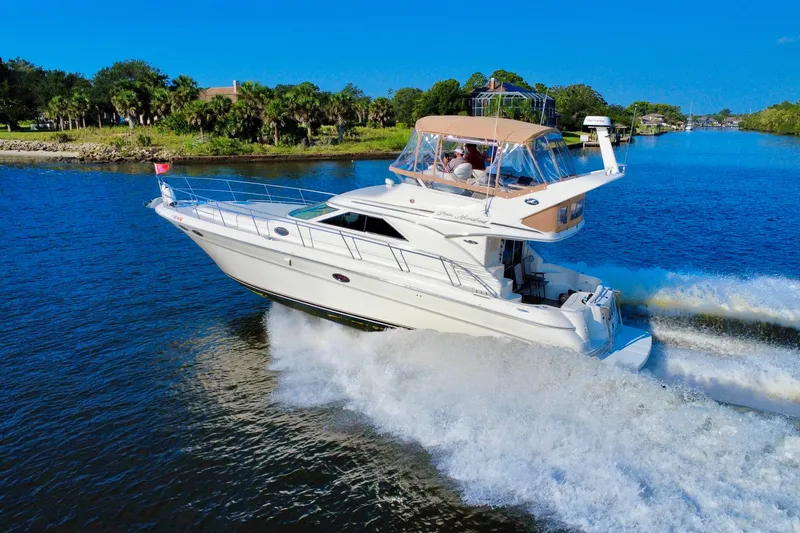 Slide: The Image of 2003 Sea Ray 400 Sedan Bridge cruising on a scenic waterway under clear blue skies. - 4
