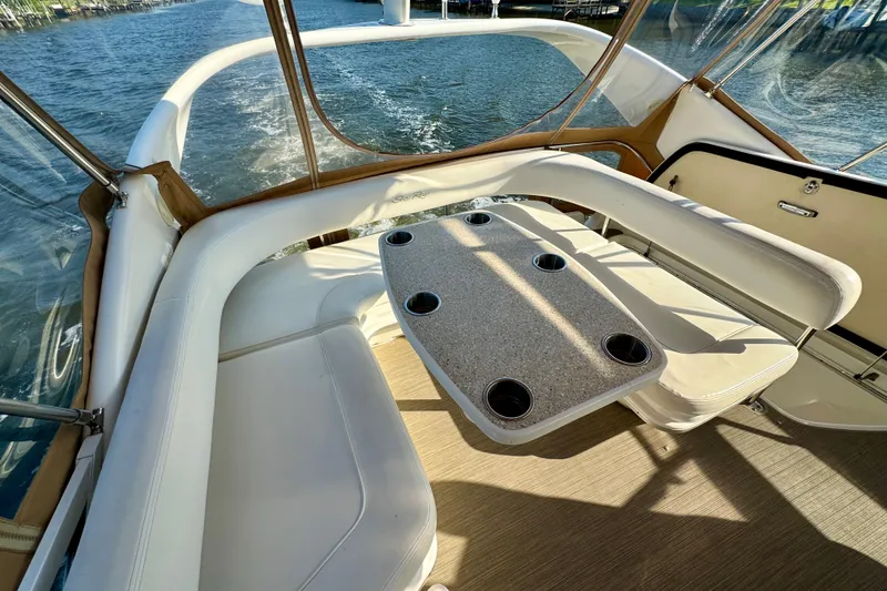 Slide: The Image of 2003 Sea Ray 400 Sedan Bridge interior with seating and table, overlooking water. - 47