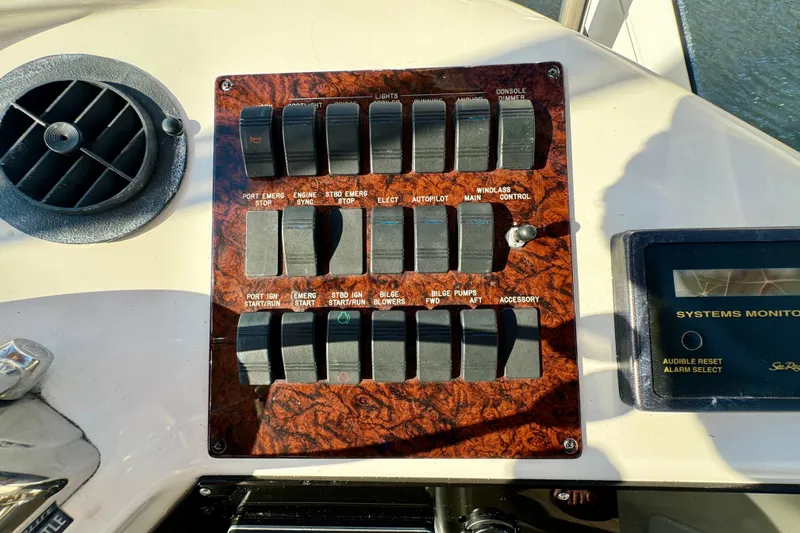 Slide: The Image of Control panel of a 2003 Sea Ray 400 Sedan Bridge yacht with various switches and systems monitor. - 49