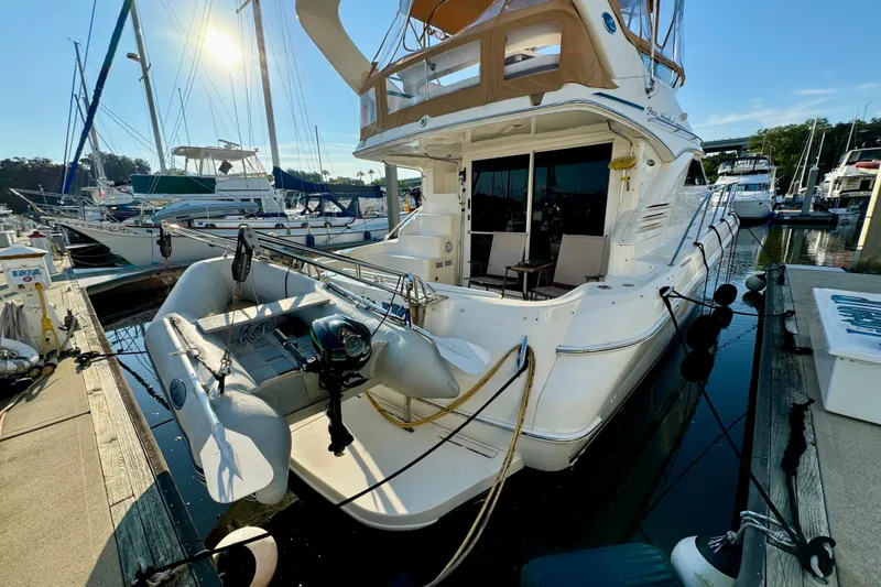 Slide: The Image of 2003 Sea Ray 400 Sedan Bridge yacht docked at marina with inflatable boat attached. - 55