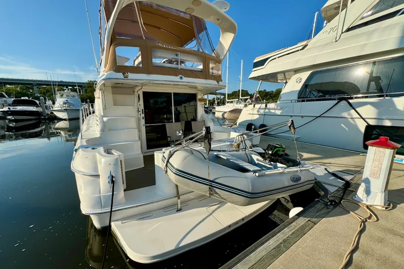 Slide: The Image of 2003 Sea Ray 400 Sedan Bridge yacht docked with inflatable boat on platform. - 58