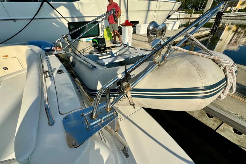 Slide: The Image of 2003 Sea Ray 400 Sedan Bridge with dinghy on deck at marina. - 59