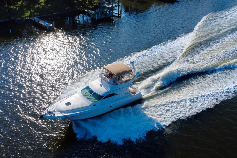 Slide: The Image of 2003 Sea Ray 400 Sedan Bridge cruising on a sunlit waterway. - 7