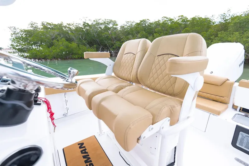 Slide: The Image of 2026 Sportsman Heritage 231 Center Console boat displayed in showroom with powerful engine. - 6