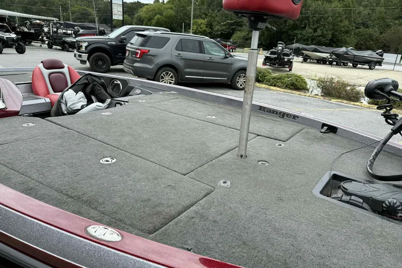 Slide: The Image of 2014 Ranger Z521 Comanche boat with red seats and spacious deck, parked outdoors. - 10