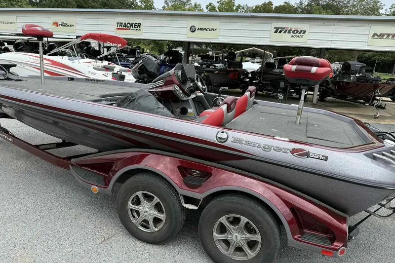 Slide: The Image of 2014 Ranger Z521 Comanche boat with red accents, parked at a dealership. - 12