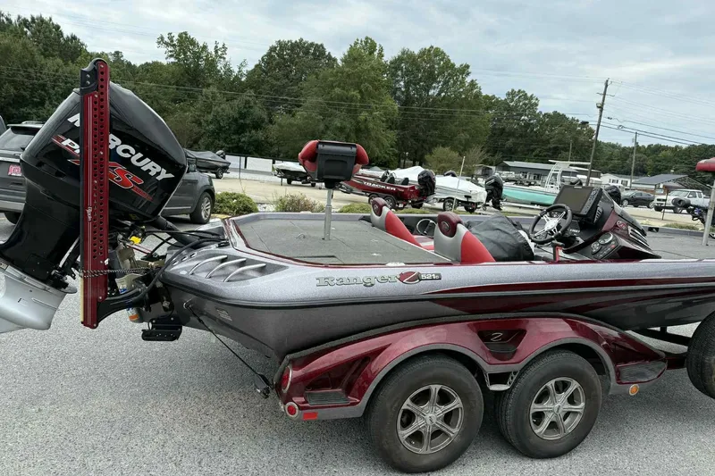 Slide: The Image of 2014 Ranger Z521 Comanche boat with Mercury engine, parked outdoors. - 2