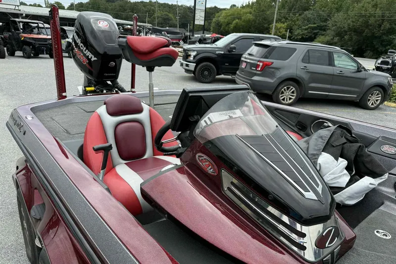 Slide: The Image of 2014 Ranger Z521 Comanche boat with red and gray seating, parked outdoors. - 9