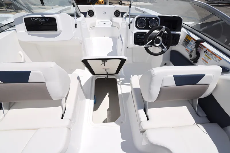 Slide: The Image of 2026 Hurricane SunDeck 2050 OB boat with outboard motor, docked near a fence. - 10