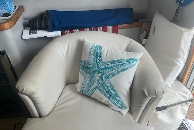 Slide: The Image of Interior of 1991 Sea Ray 370 Sedan Bridge with starfish pillow on white chair. - 10