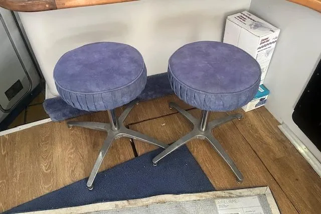 Slide: The Image of Two blue swivel stools on a wooden floor inside a 1991 Sea Ray 370 Sedan Bridge. - 11