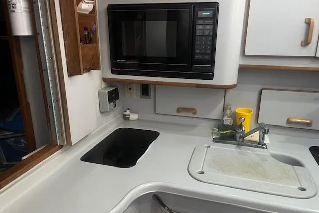Slide: The Image of 1991 Sea Ray 370 Sedan Bridge kitchen with microwave, sink, and countertop. - 5