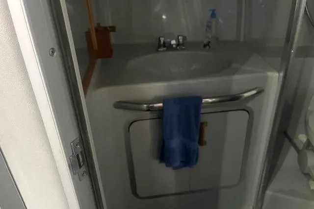 Slide: The Image of 1991 Sea Ray 370 Sedan Bridge bathroom with sink, towel, and toiletries. - 8