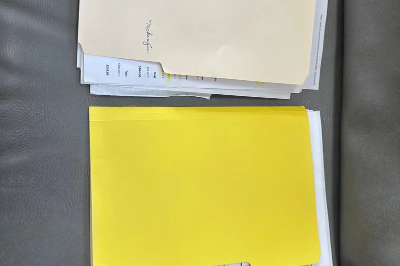 Slide: The Image of Yellow and beige folders on a gray surface, containing documents. - 3