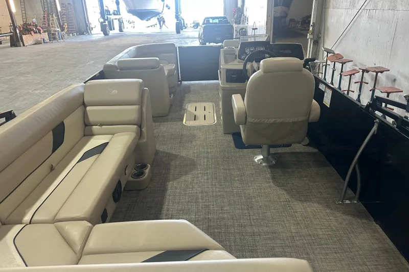 Slide: The Image of 2021 SunCatcher Select Series 322C pontoon boat interior with beige seating and steering console. - 5