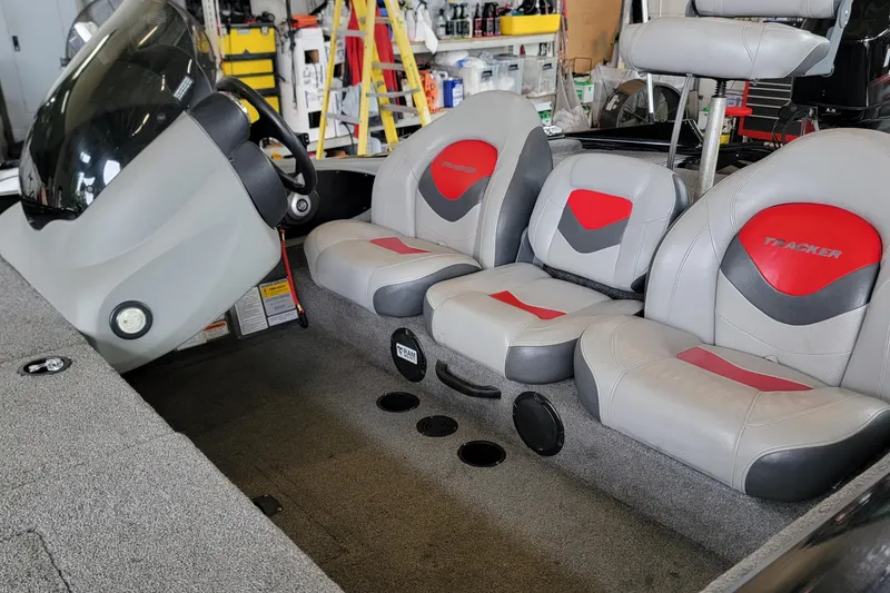 Slide: The Image of 2015 Tracker Pro Team 175 TXW boat interior with gray and red seating. - 2