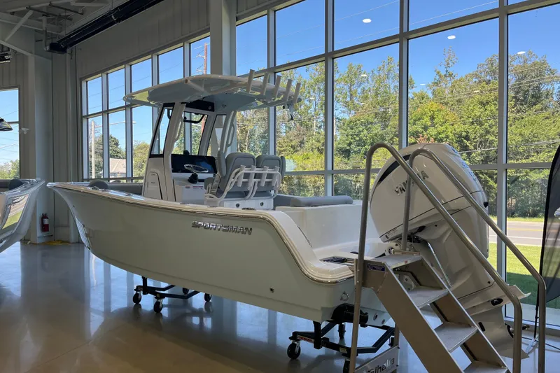 Slide: The Image of 2026 Sportsman Open 232 Center Console boat displayed indoors with large windows. - 0