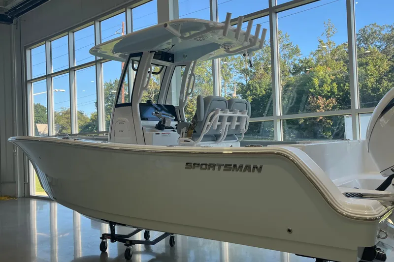 Slide: The Image of 2026 Sportsman Open 232 Center Console boat displayed indoors with large windows. - 1