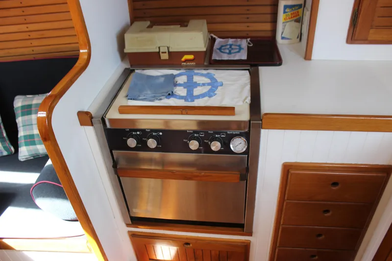 Slide: The Image of 1988 Express Yachting Scout 30 interior kitchen with stove and wooden cabinetry. - 10
