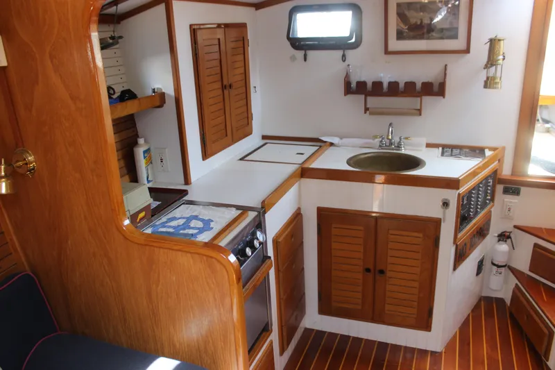 Slide: The Image of 1988 Express Yachting Scout 30 interior with wooden cabinetry and compact kitchen area. - 12