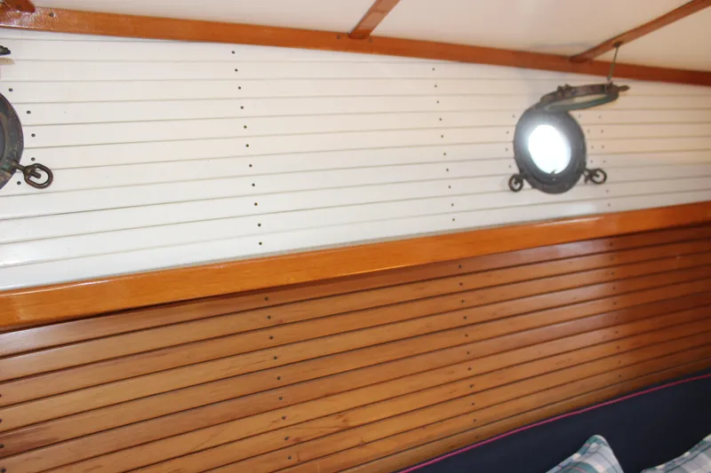 Slide: The Image of Interior of 1988 Express Yachting Scout 30 with wooden paneling and portholes. - 17
