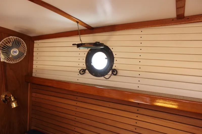 Slide: The Image of Interior of 1988 Express Yachting Scout 30 with porthole and wooden paneling. - 18