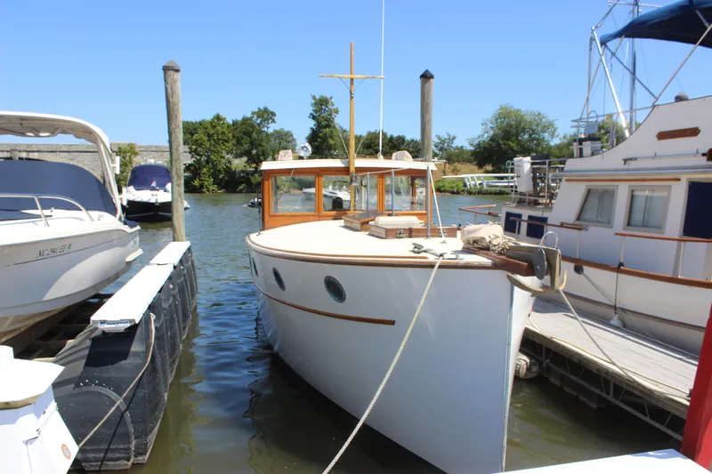 Slide: The Image of 1988 Express Yachting Scout 30 docked at a marina on a sunny day. - 2