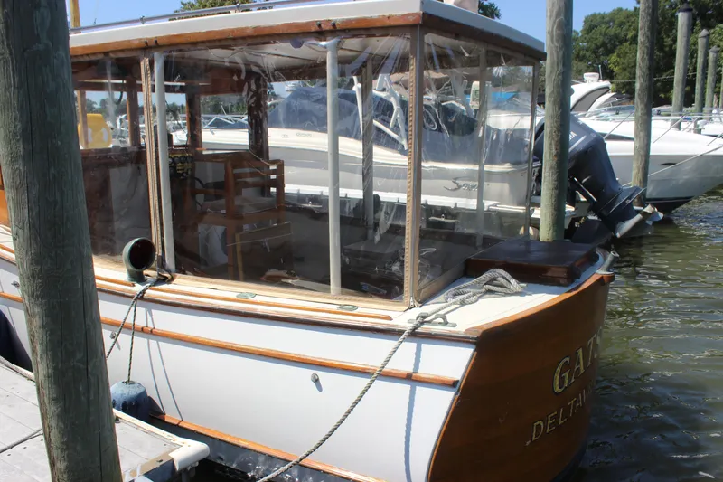 Slide: The Image of 1988 Express Yachting Scout 30 docked, featuring wooden trim and clear enclosure. - 3