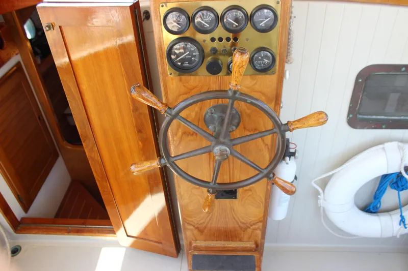 Slide: The Image of 1988 Express Yachting Scout 30 helm with wooden wheel and instrument panel. - 32
