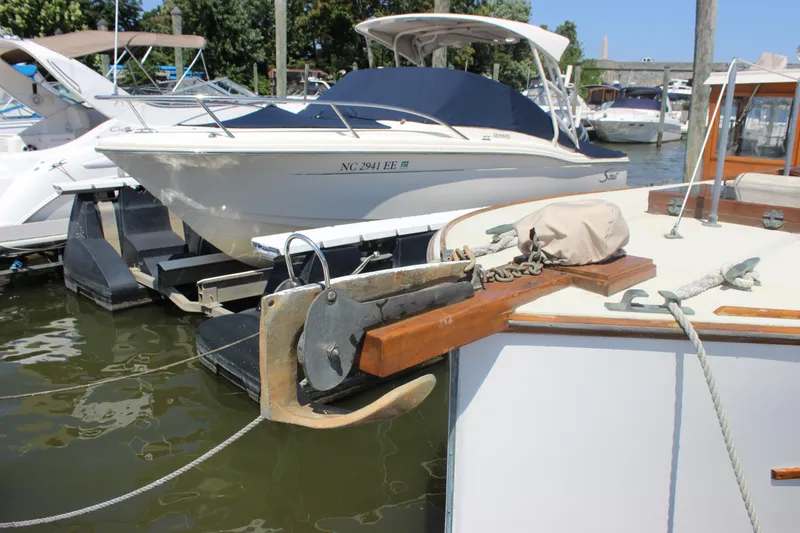 Slide: The Image of 1988 Express Yachting Scout 30 docked, featuring anchor and mooring lines. - 37