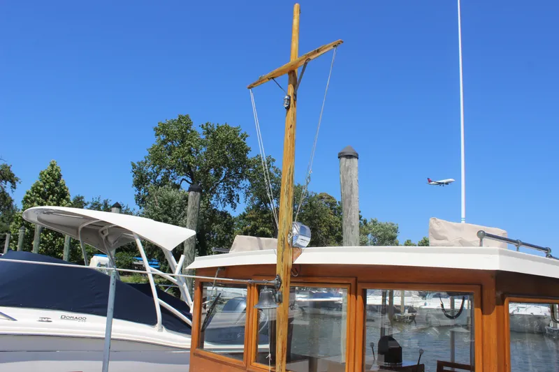 Slide: The Image of 1988 Express Yachting Scout 30 docked, with trees and airplane in the background. - 39