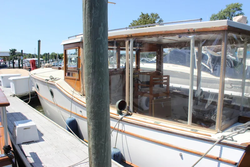 Slide: The Image of 1988 Express Yachting Scout 30 docked at marina, showcasing classic design and wooden accents. - 4