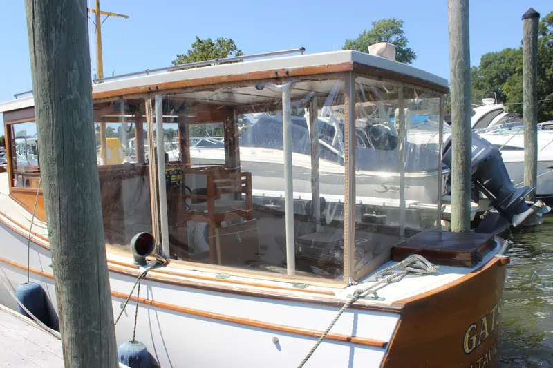 Slide: The Image of 1988 Express Yachting Scout 30 docked, featuring wooden details and clear enclosures. - 40