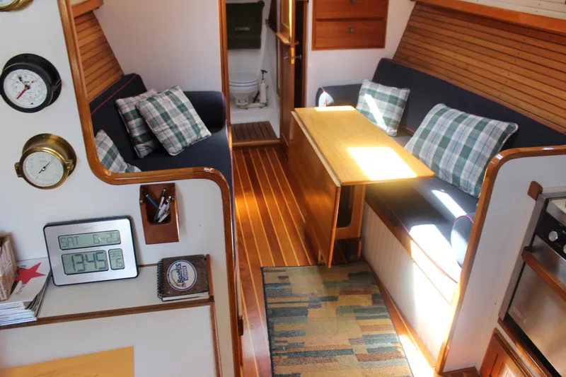 Slide: The Image of Interior of 1988 Express Yachting Scout 30, featuring cozy seating and nautical decor. - 6
