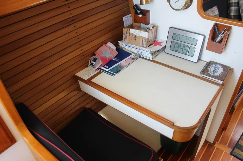 Slide: The Image of 1988 Express Yachting Scout 30 cabin interior with desk, clock, and nautical decor. - 9