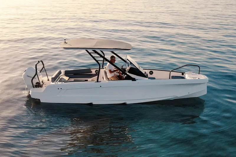 The Image of 2023 Axopar 22 T-Top boat cruising on calm water at sunset. - 0