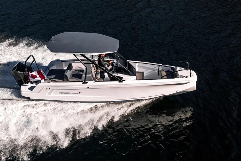 Slide: The Image of 2023 Axopar 22 T-Top boat cruising on water with Canadian flag. - 3