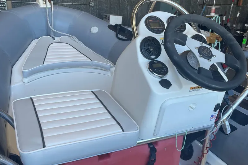 Slide: The Image of 2014 Zodiac Bayrunner 420 boat interior with steering console and cushioned seating. - 4