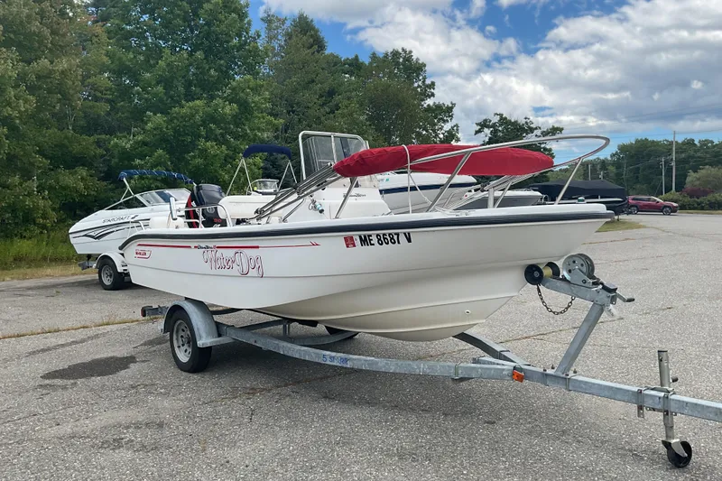 Slide: The Image of 2000 Boston Whaler Dauntless 16 boat on trailer, parked outdoors under cloudy sky. - 1