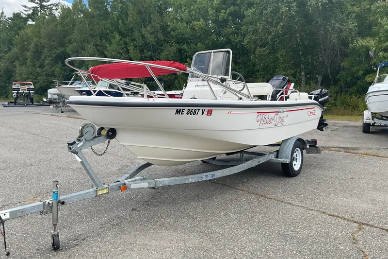 Slide: The Image of 2000 Boston Whaler Dauntless 16 boat on trailer, parked outdoors with trees in background. - 3