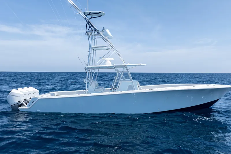 Slide: The Image of 2023 SeaVee 390Z boat cruising on open ocean under clear blue sky. - 2