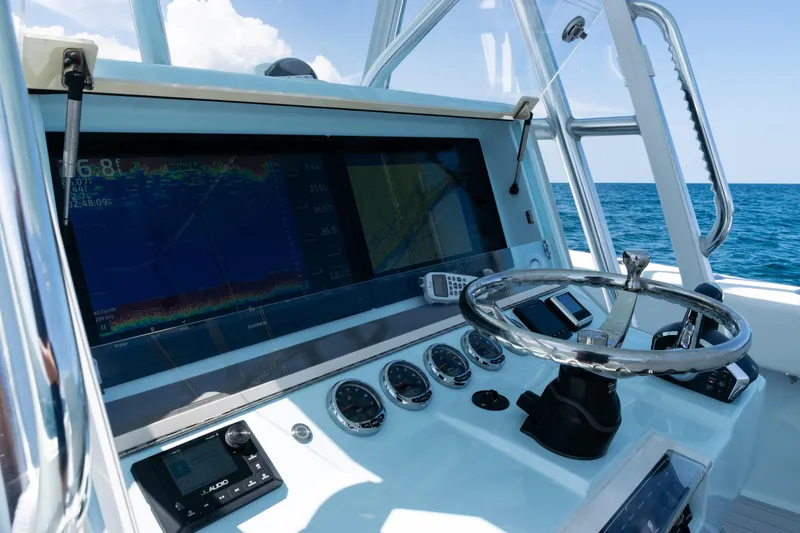 Slide: The Image of 2023 SeaVee 390Z boat console with steering wheel and navigation system on open water. - 30
