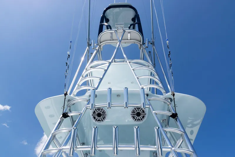 Slide: The Image of 2023 SeaVee 390Z boat docked with four outboard engines, surrounded by palm trees. - 55