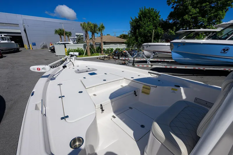 Slide: The Image of 2021 Blue Wave 2600 PureBay boat, white interior, docked outdoors under clear blue sky. - 10
