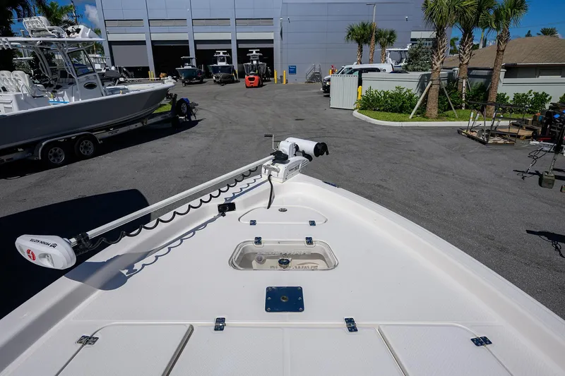 Slide: The Image of 2021 Blue Wave 2600 PureBay boat at a marina with palm trees and other boats. - 12